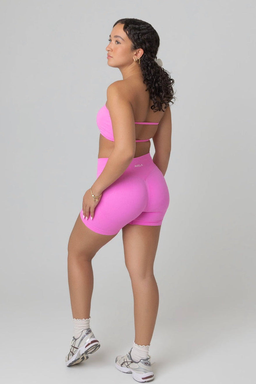 Woman wearing a pink sports outfit on a white background